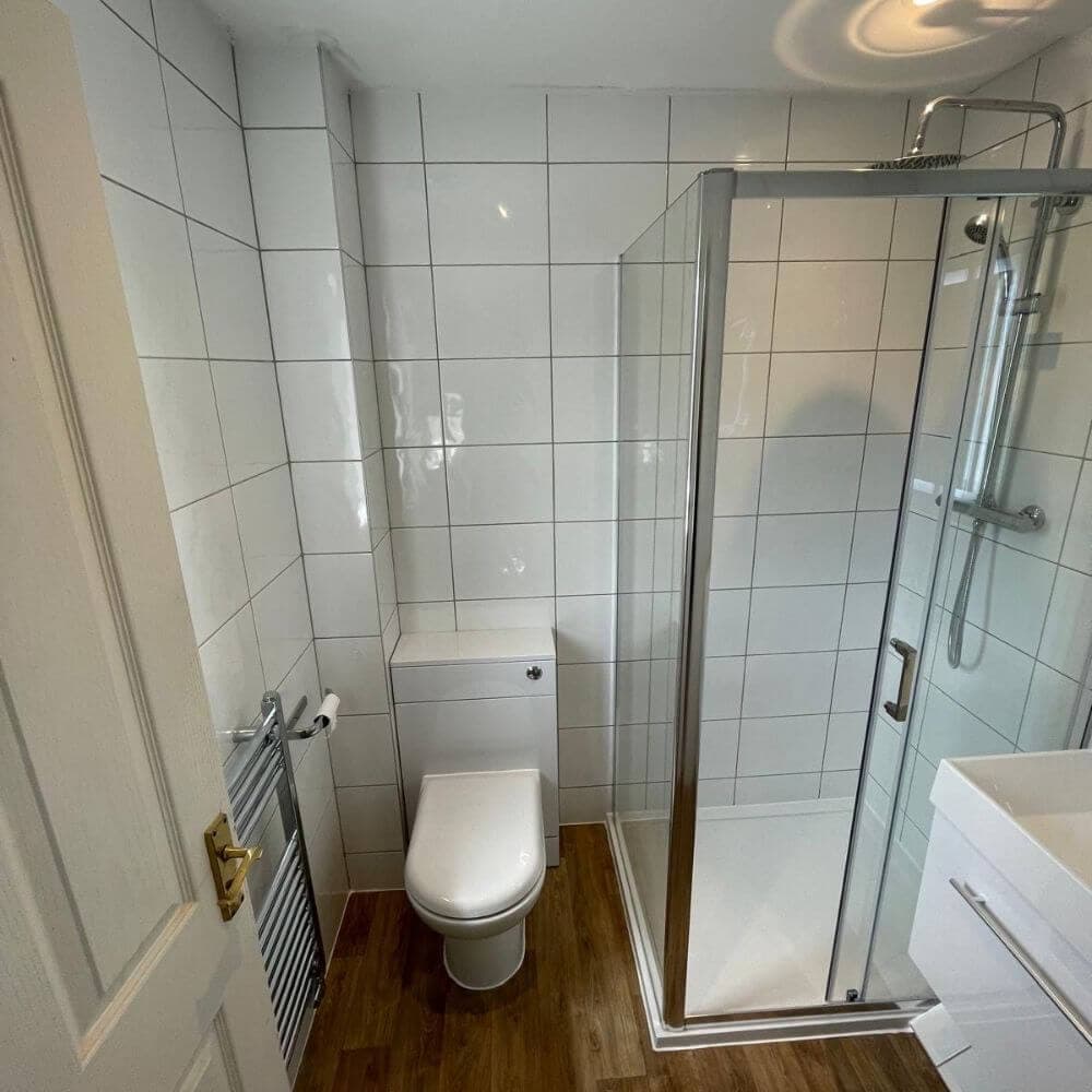Wood-effect vinyl flooring fitted in a bathroom by JM Plumbing Services