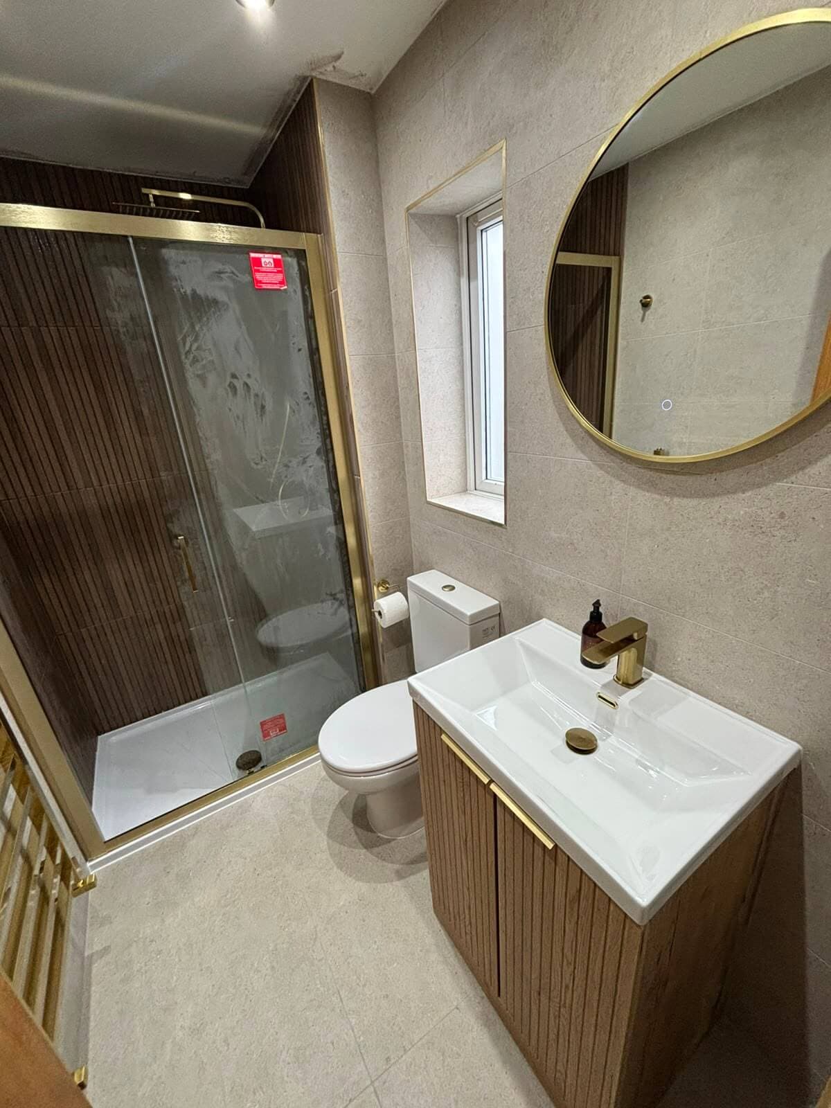 Bathroom renovation in Cardiff with a brass-framed walk-in shower enclosure, completed by JM Plumbing Services